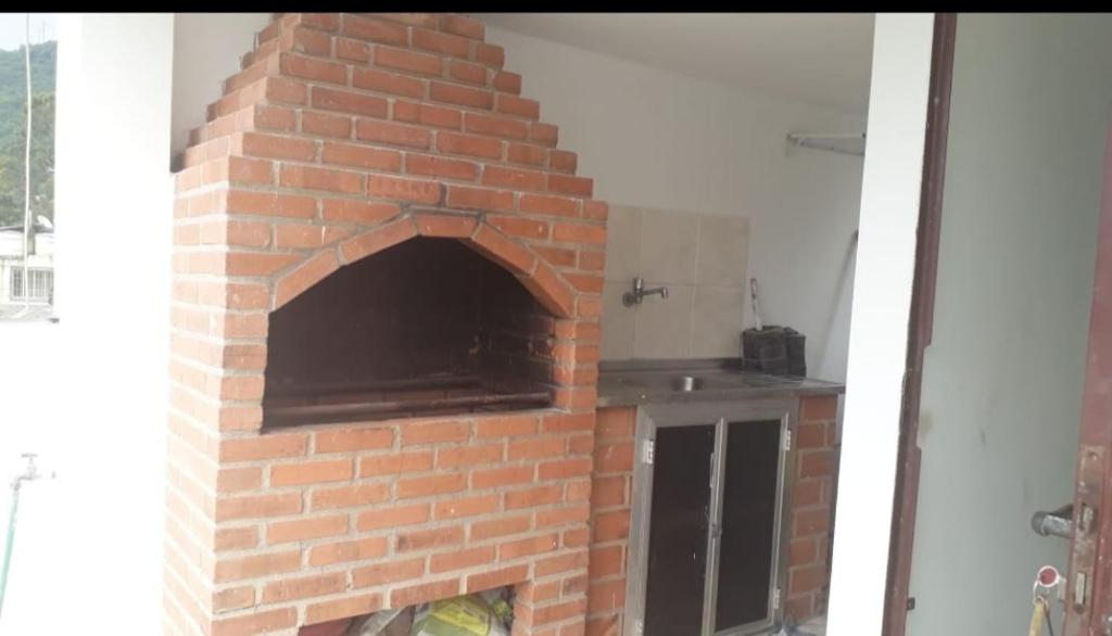 een bakstenen open haard met een pizza-oven in een kamer bij Casa de Praia Ibicuí in Mangaratiba