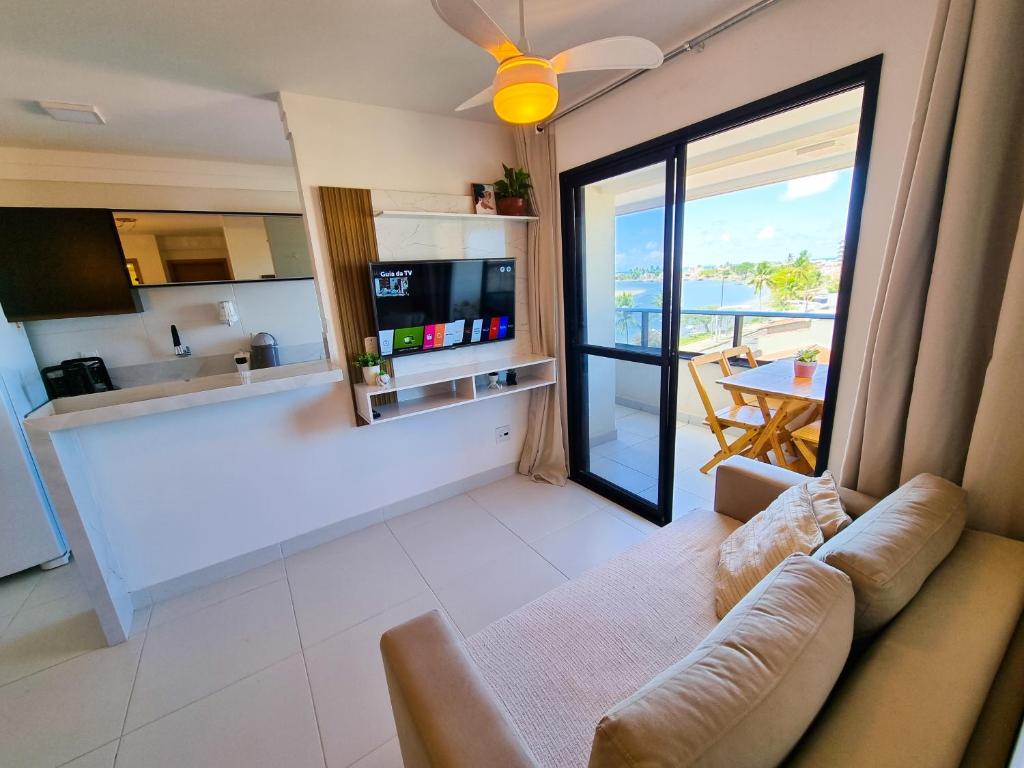 a living room with a couch and a view of a kitchen at Apartamento Paraiso do Pontal in Ilhéus