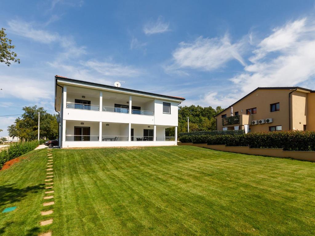 a large lawn in front of a white building at Apartment Aria in Poreč