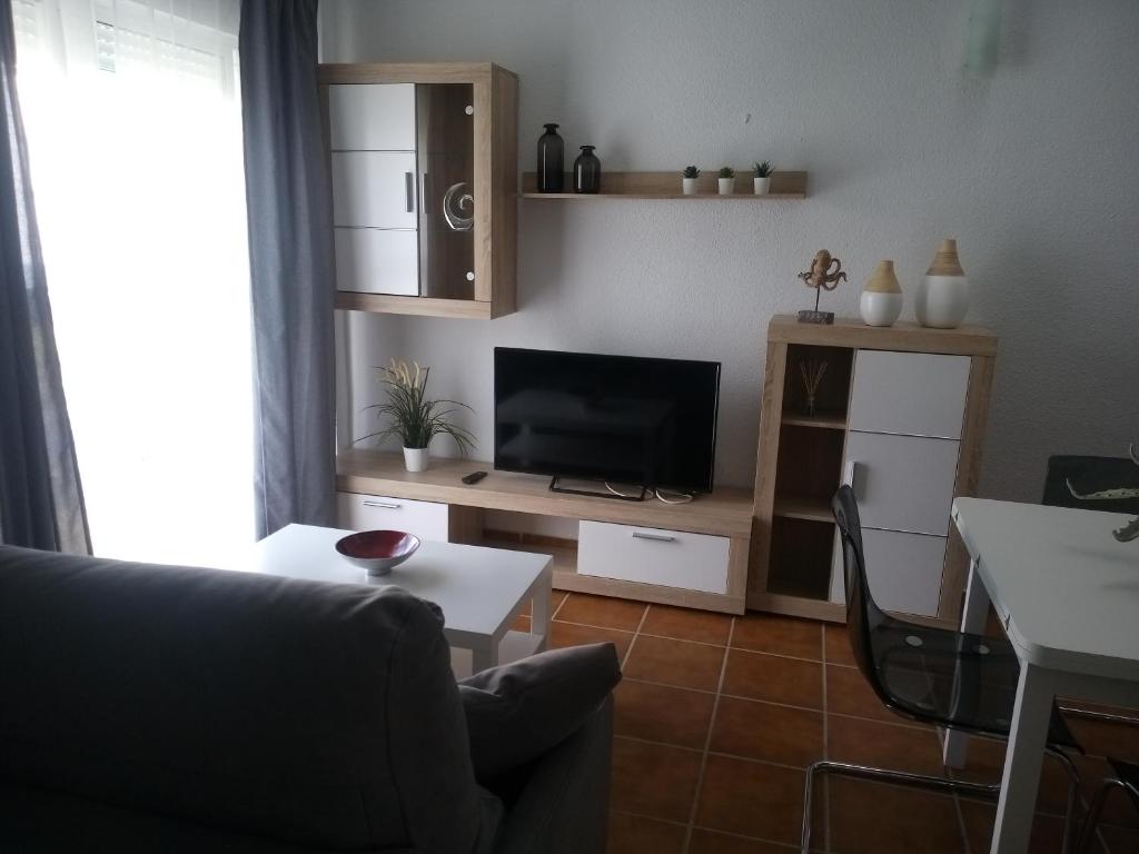 sala de estar con sofá y TV en ALCARAVAN 50, en Huelva