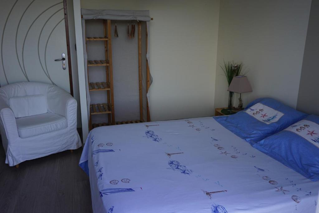 een slaapkamer met een bed, een stoel en een ladder bij Chambre d'hôtes le Berceau in Meschers-sur-Gironde