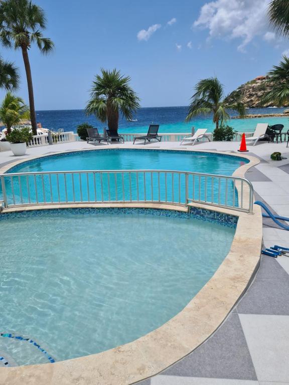 a swimming pool with the ocean in the background at Blue Emerald on Blue Bay Beach in Blue Bay