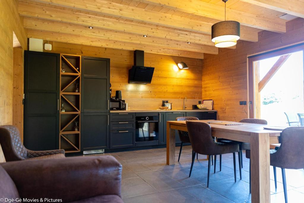a kitchen with a table and chairs and a dining room at Les Jardins du Hérisson Chalet 2 in Bonlieu