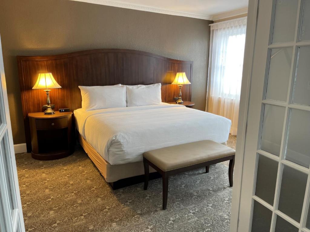 una camera con un letto e una sedia e due lampade di The Americus Hotel, Trademark Collection by Wyndham ad Allentown