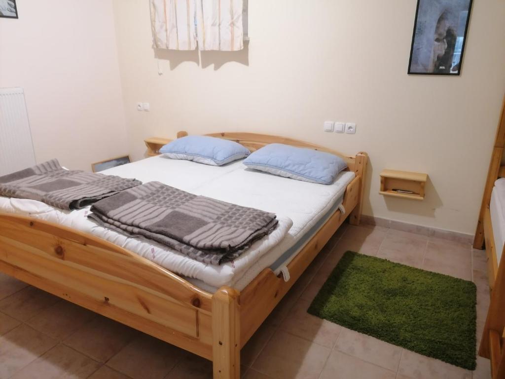 a wooden bed in a room with a green rug at APARTMA ROŽLE - ROGLA in Vitanje
