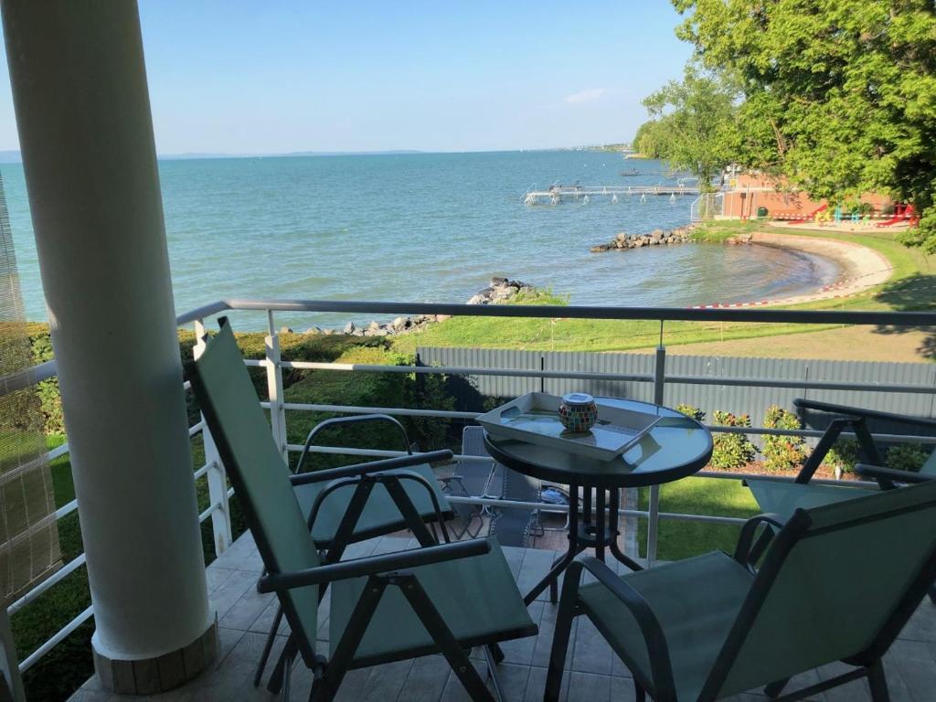 a balcony with a table and chairs and the ocean at Panoráma Villa in Balatonboglár