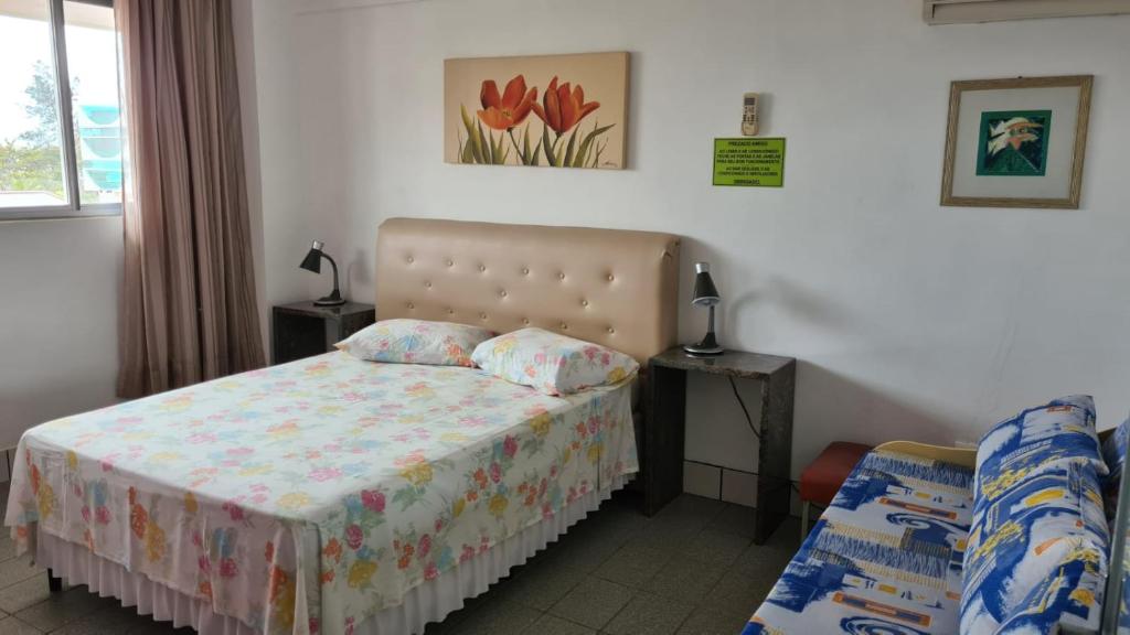 a small bedroom with a bed and a chair at PRAIA 4 ILHAS Apartamento 1 Quarto a 50M da Praia in Bombinhas