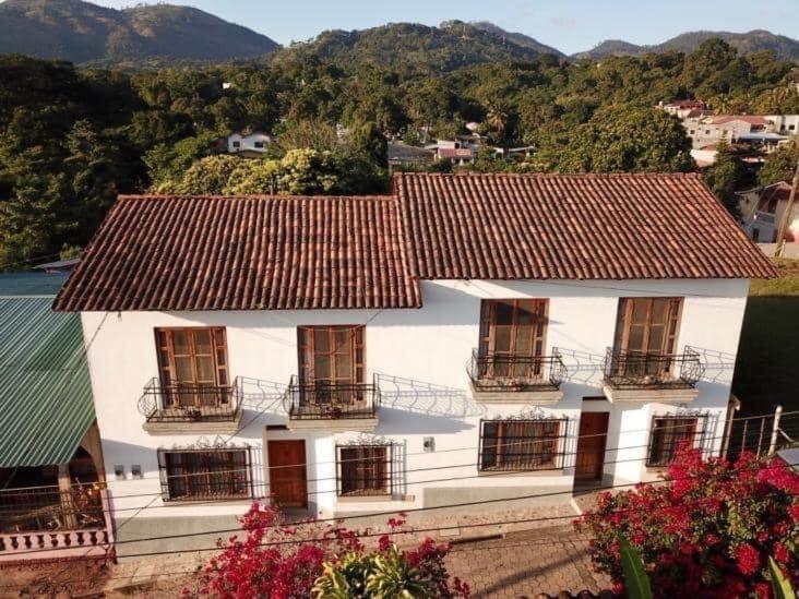 Casa blanca con ventanas y techo en La Casa de Don Santiago Townhouse, en Copan Ruinas