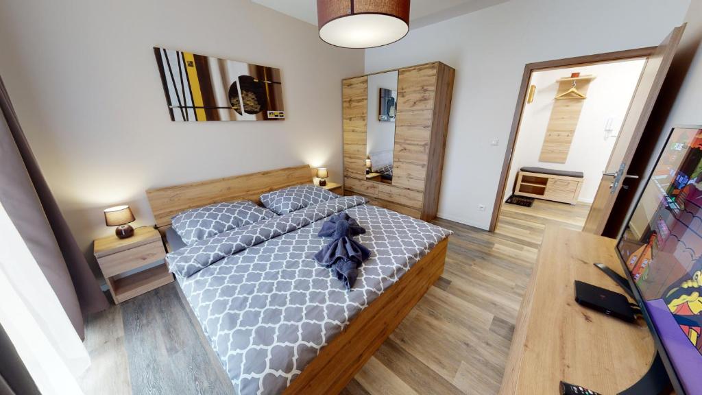 1 dormitorio con 1 cama y suelo de madera en Apartmán Tobias, PRIMO, Starý Smokovec en Stary Smokovec