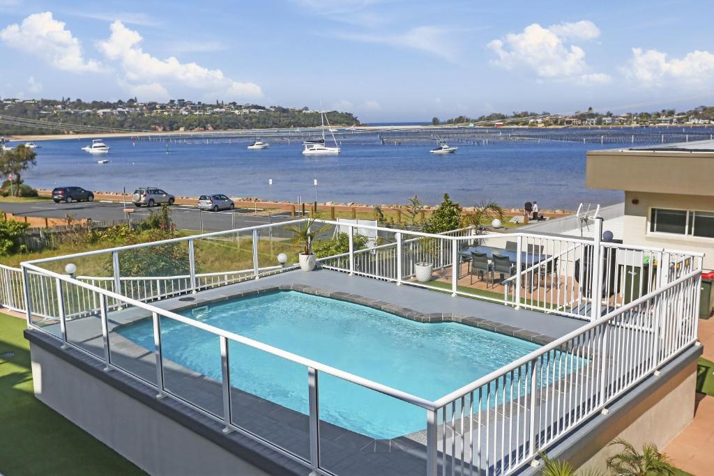 uma piscina numa varanda com vista para a água em Crown Apartments em Merimbula