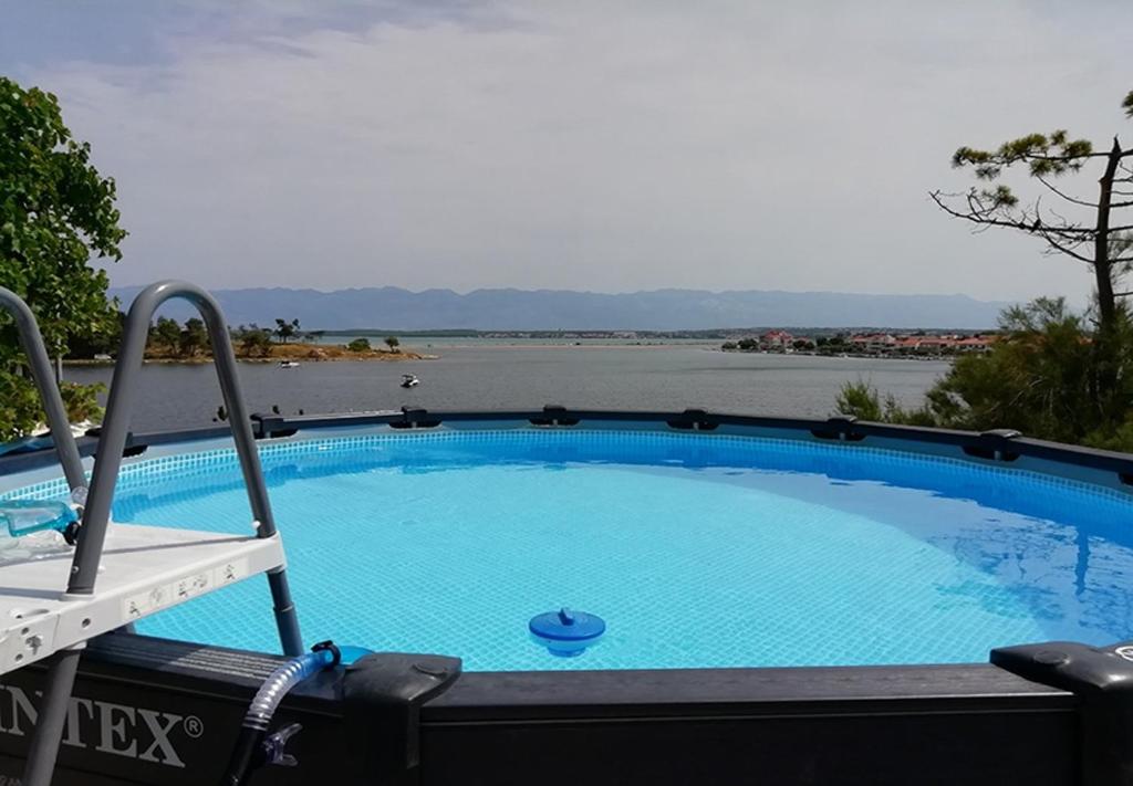 een zwembad met uitzicht op het water bij Apartments Ljilja-10m from sea in Nin