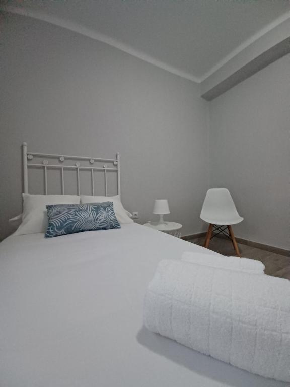 1 dormitorio con cama blanca y almohada azul en Sherryhouse, en Jerez de la Frontera
