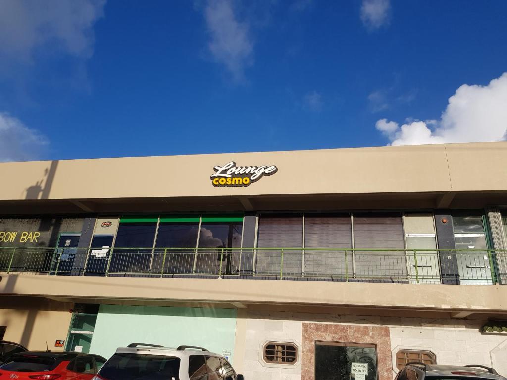 a building with a car parked in a parking lot at 1박전용 cosmo lounge 휴계실 in Saipan