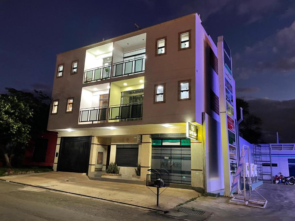 Un grand bâtiment avec des lumières sur son côté dans l'établissement WilMar Apart Hotel, à Encarnación