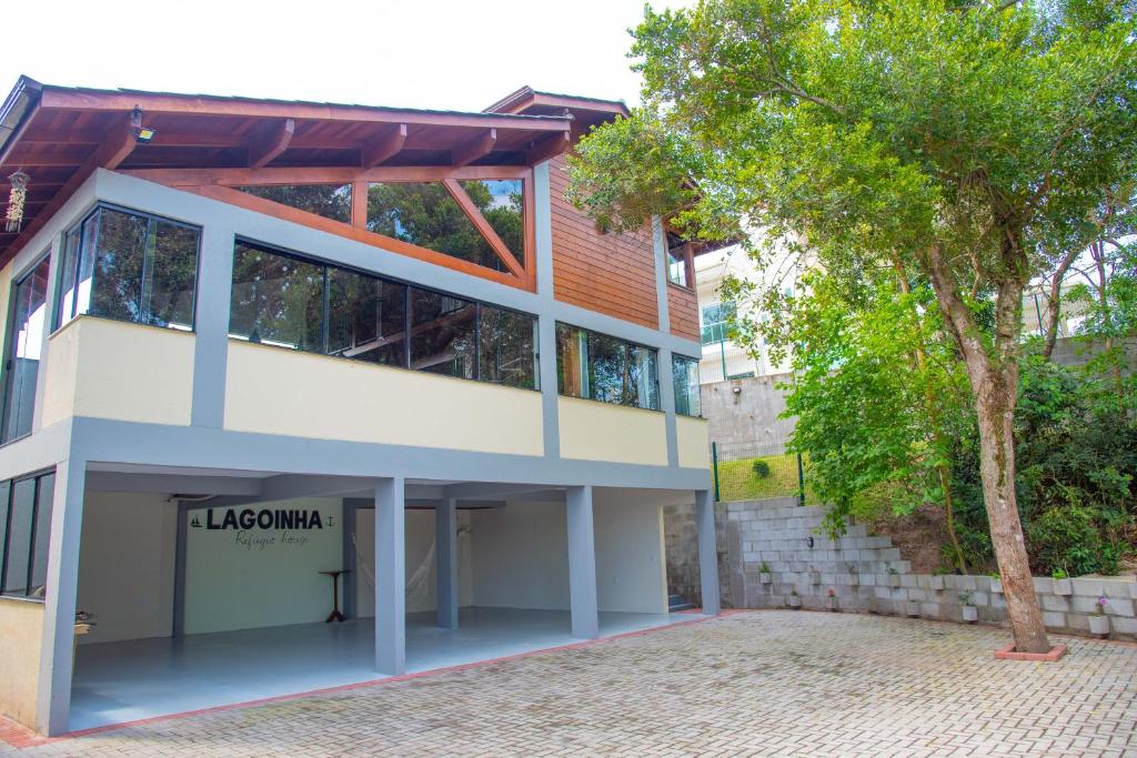 un edificio con un árbol delante de él en Lagoinha Refúgio House, en Florianópolis