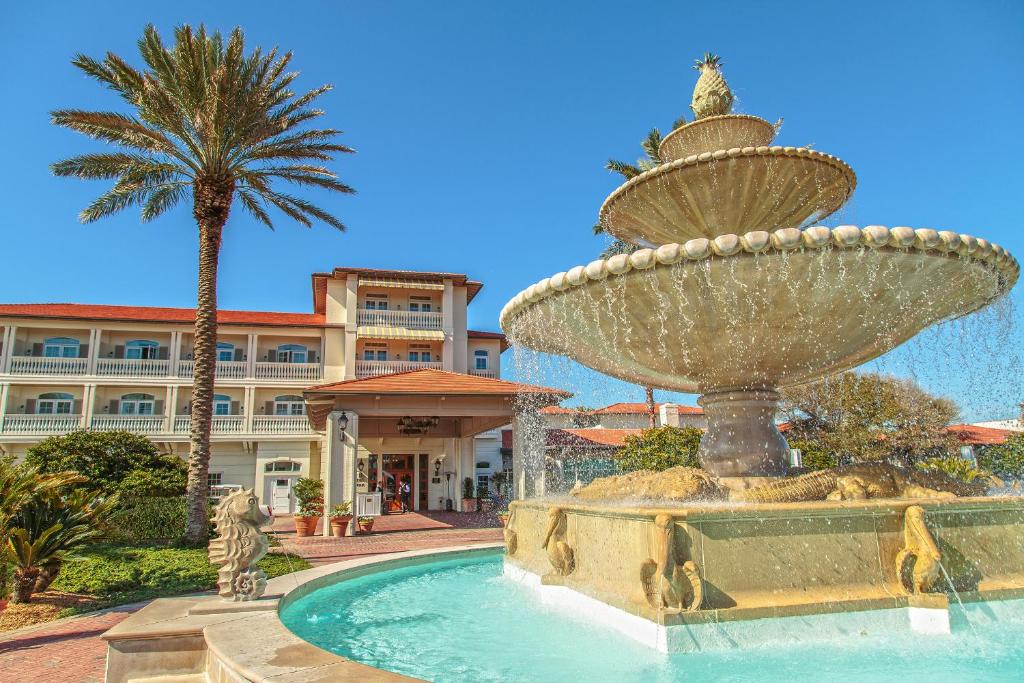 a fountain in front of a hotel with a palm tree at Ponte Vedra Inn and Club in Ponte Vedra Beach