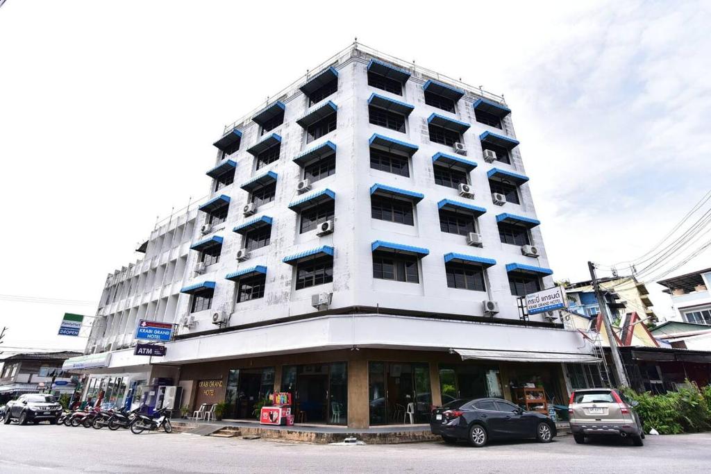 a large white building with cars parked in front of it at Krabi Grand Hotel in Krabi town