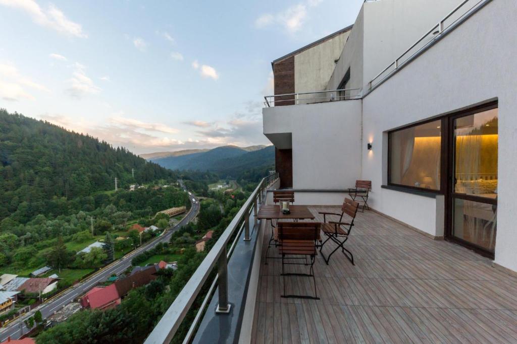 a balcony with a table and chairs on a building at Apartament Carol Sinaia in Sinaia