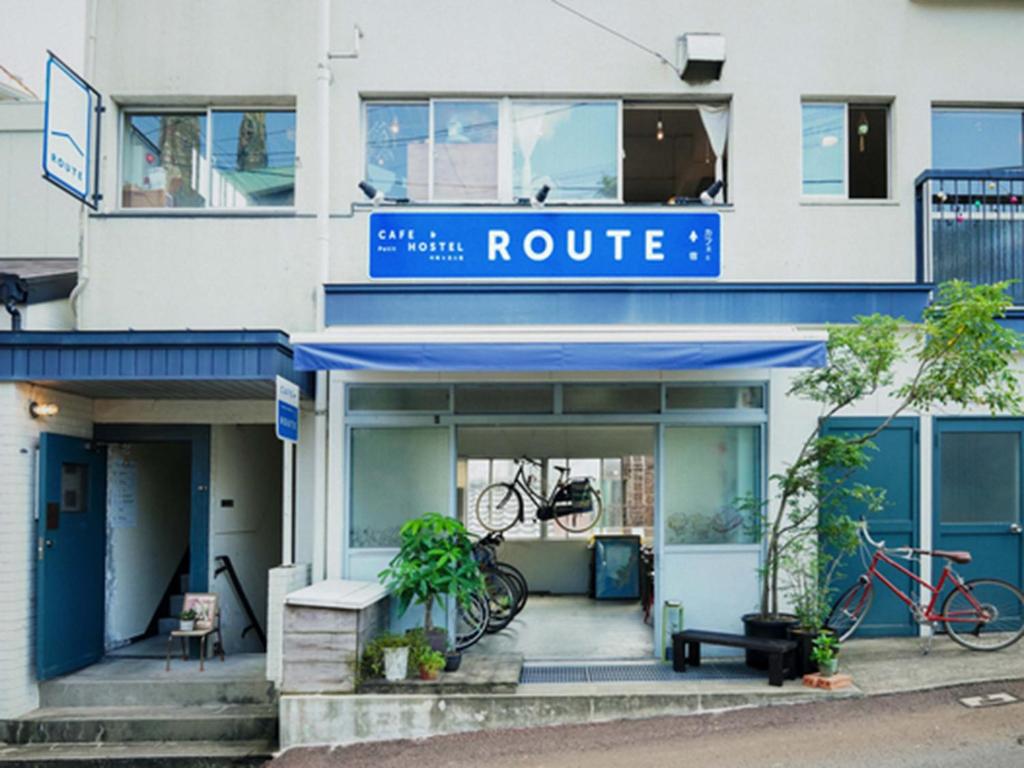 a white building with a blue route sign on it at ROUTE - Cafe and Petit Hostel in Nagasaki