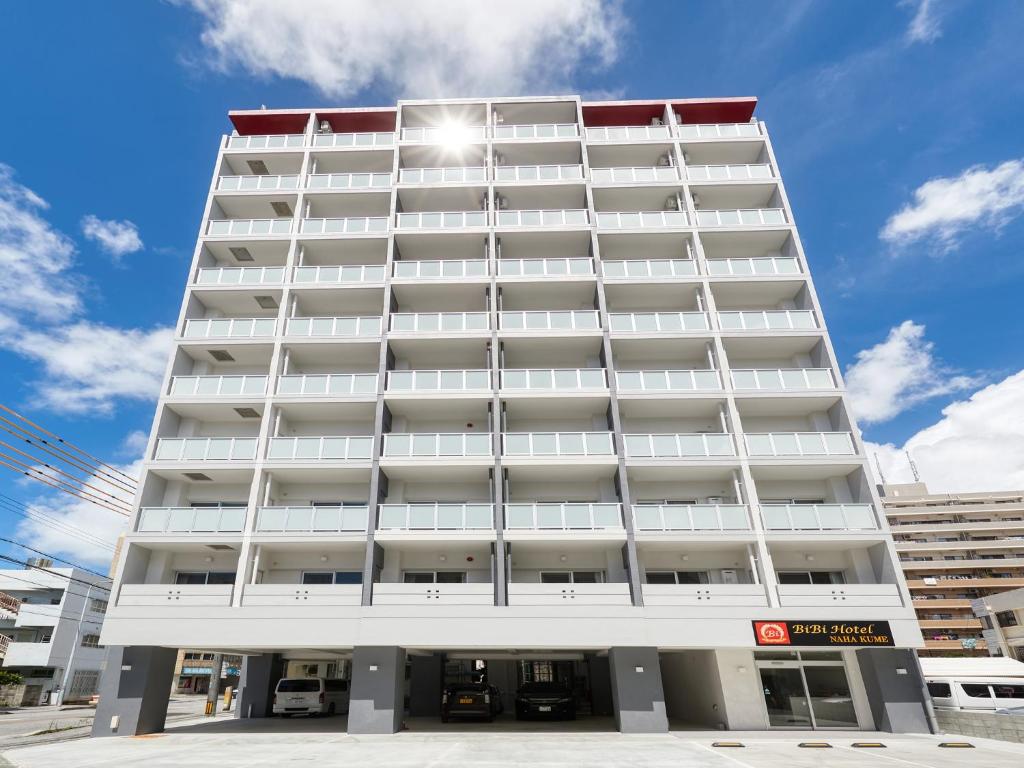 a tall white building with a lot of windows at BiBi Hotel NAHA KUME in Naha