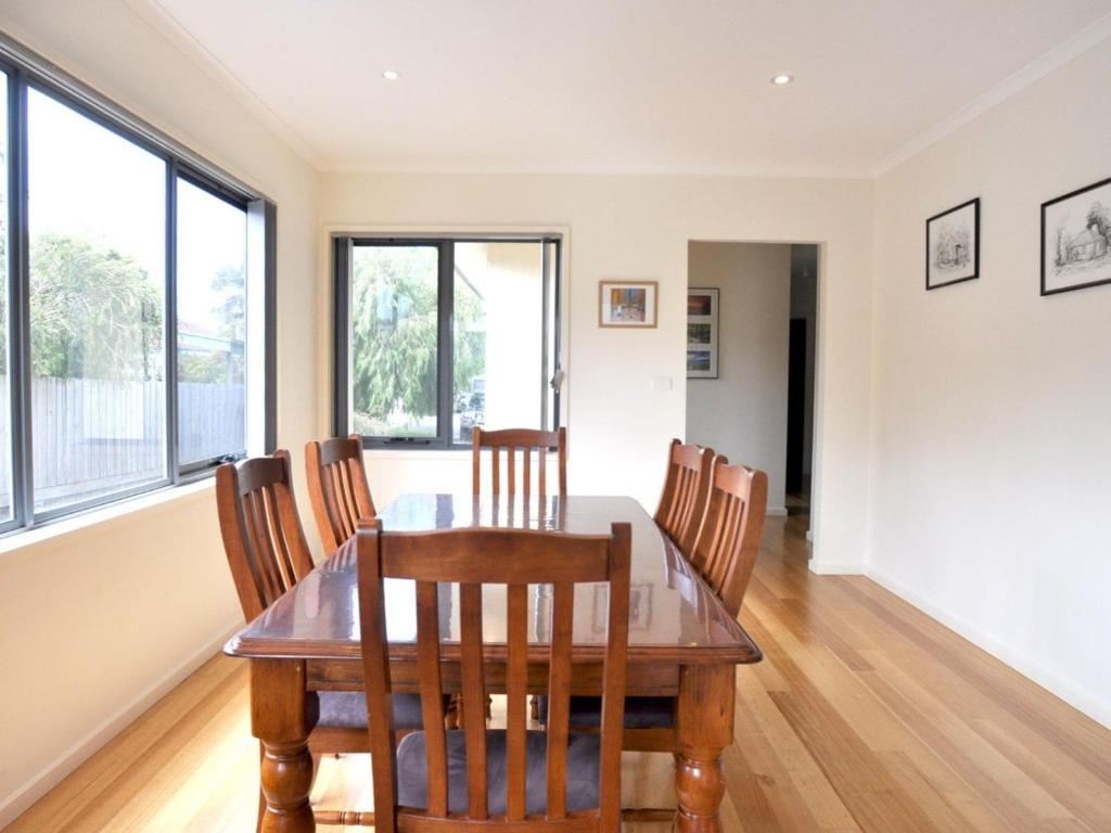 a dining room with a wooden table and chairs at Ridge End Inlet Side in Inverloch