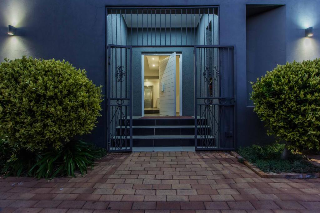 a blue house with a front door with stairs at Charlie's Spot - Norwood in Johannesburg