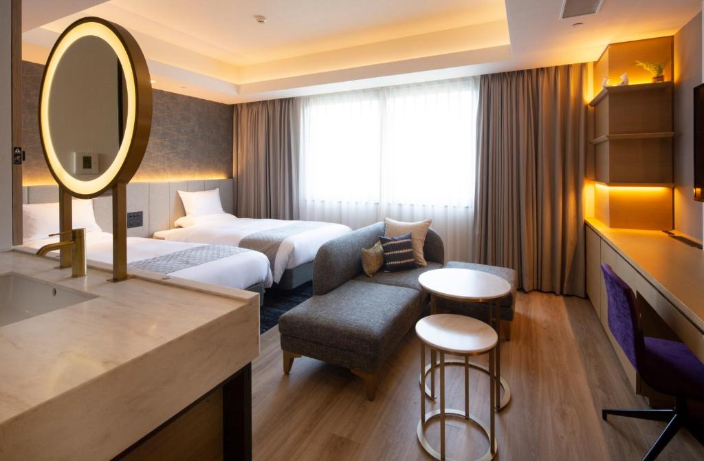 a hotel room with a bed and a mirror at Nikko Style Nagoya in Nagoya