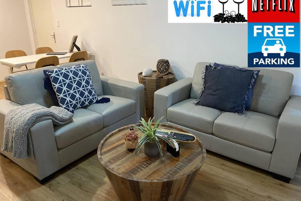 CENTRAL CLOSE SHOPS CITY AIRPORT WIFI NETFLIX PARK في بيرث: غرفة معيشة مع أريكة وطاولة قهوة