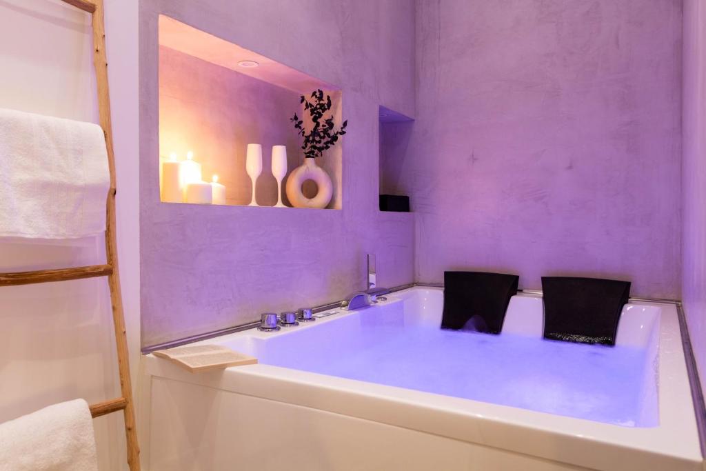 uma casa de banho roxa com uma banheira com 2 cadeiras em Les Bulles de Mona "Le 93" -PROXIMITE GARE DE LYON- em Lyon