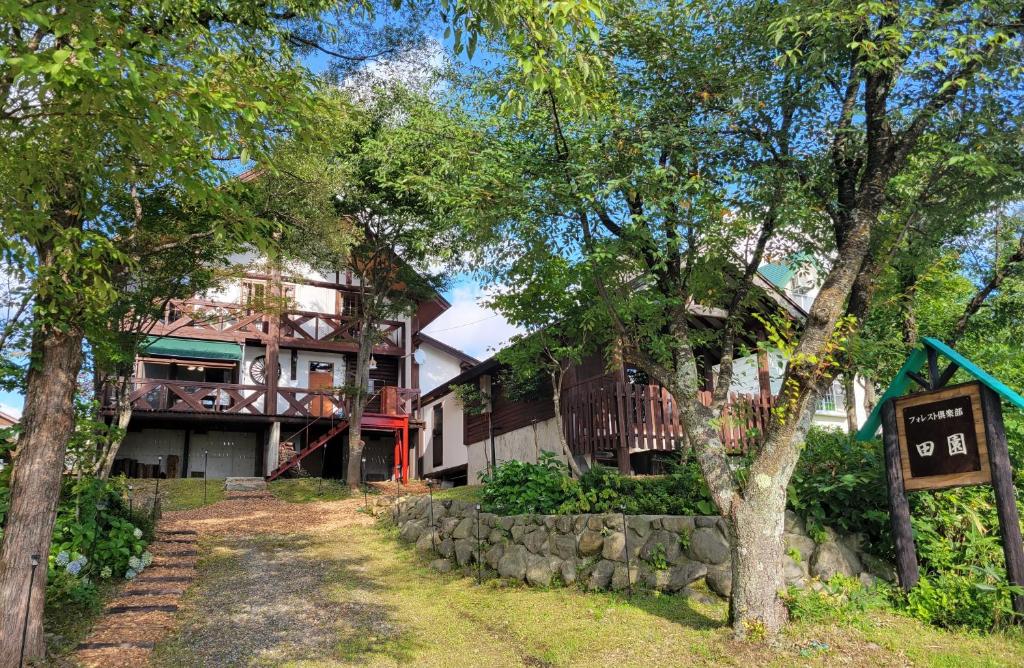 una casa con un cartel delante de ella en フォレスト倶楽部　田園, en Takano