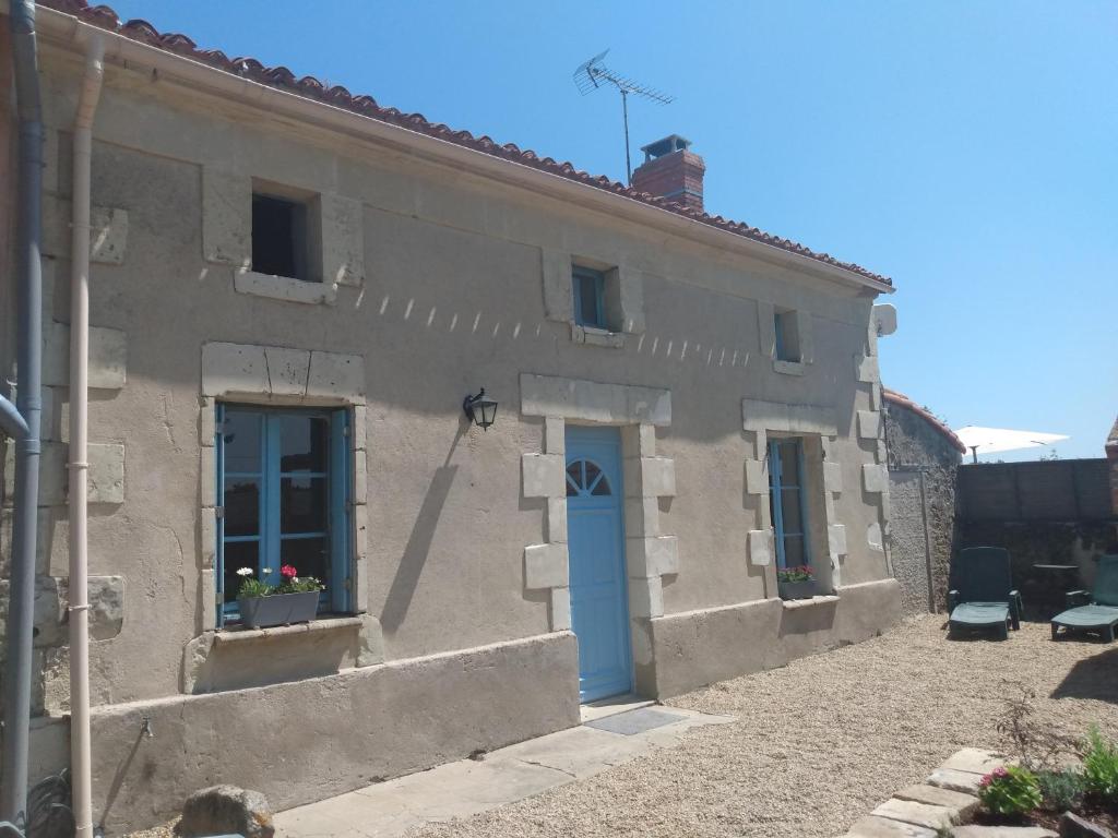 ein weißes Gebäude mit einer blauen Tür und Fenstern in der Unterkunft Lavender House - Traditional stone house oozing charm and character in Cersay