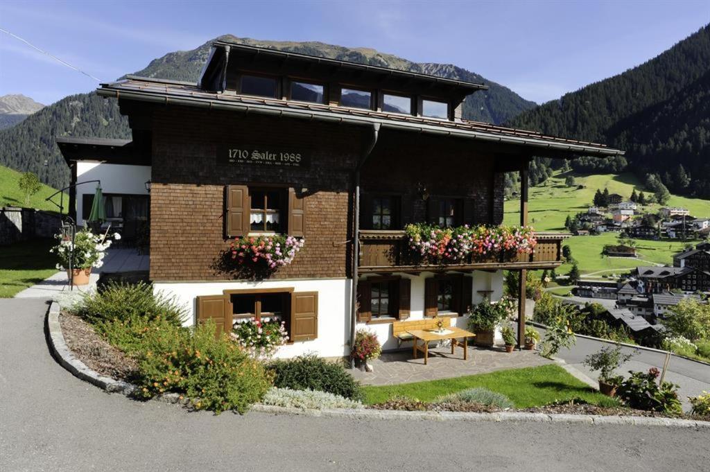 ein großes Gebäude mit Blumen davor in der Unterkunft Haus Saler in Gaschurn