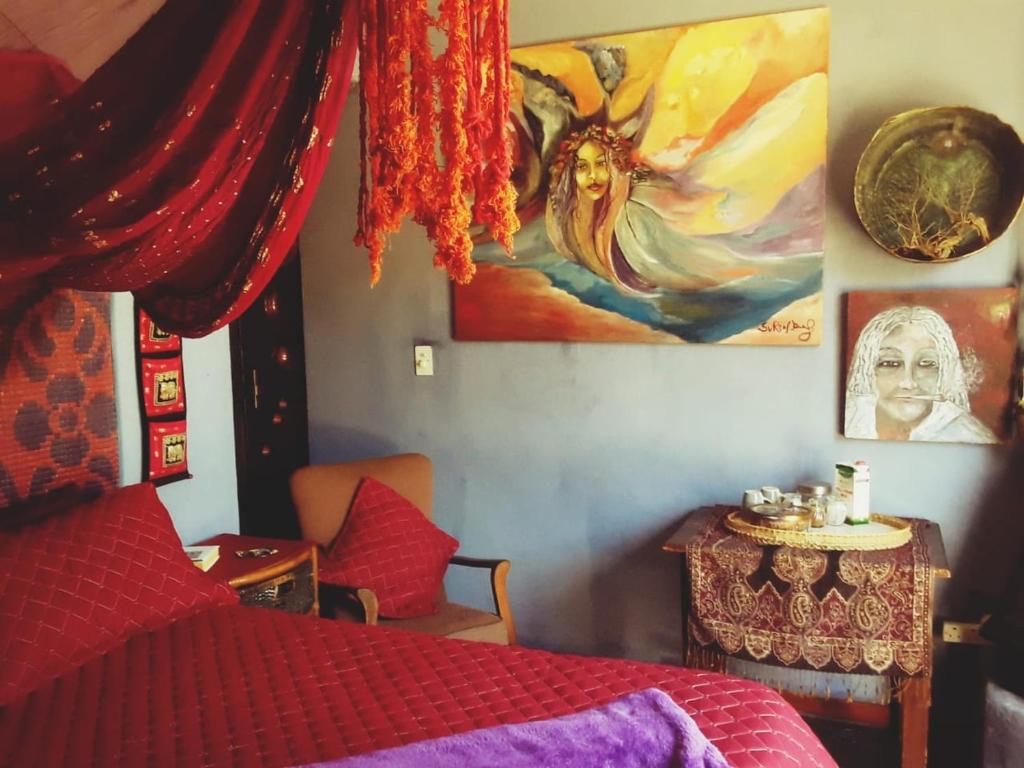 a bedroom with a bed and a painting on the wall at Calvinia Magic Garden in Calvinia