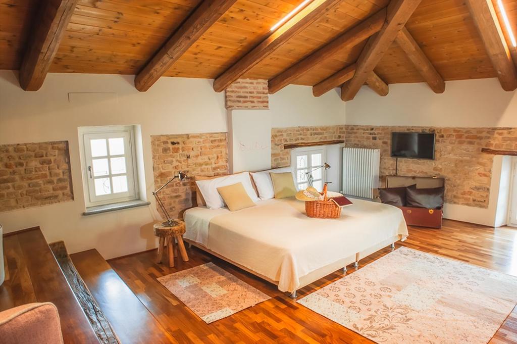 ein Schlafzimmer mit einem Bett in einem Zimmer mit Holzdecken in der Unterkunft Il Giardino sul Tetto B&B in Guarene