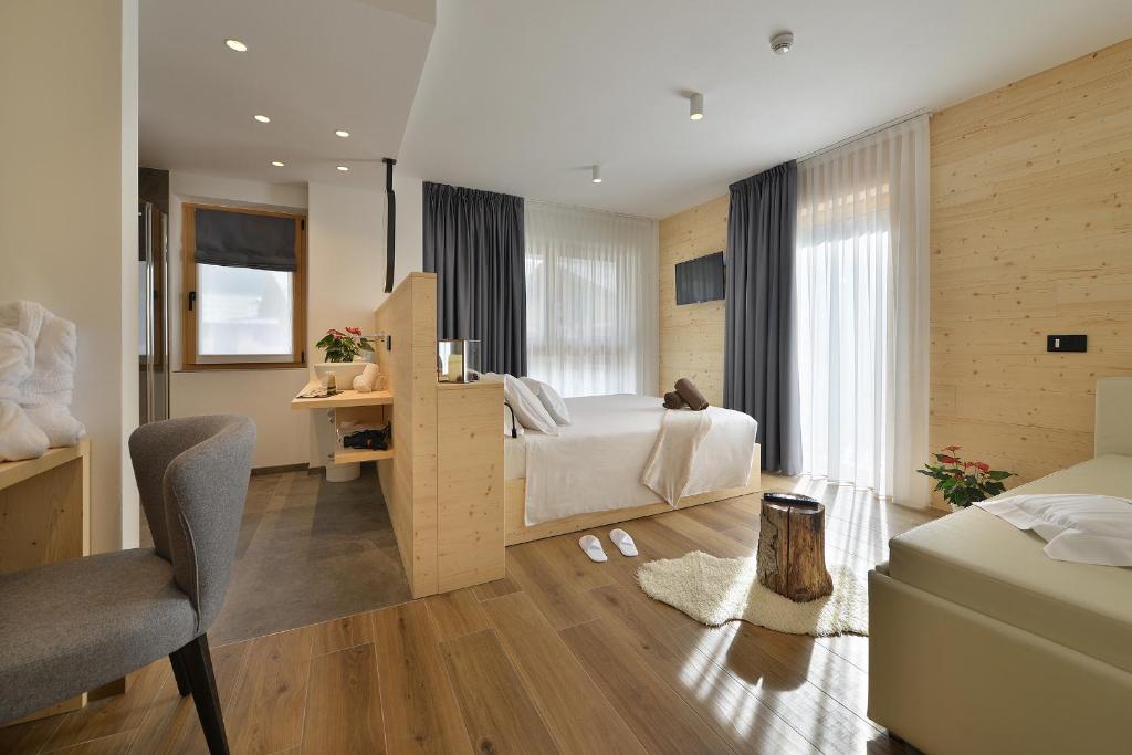 a bedroom with a bed and a desk and a chair at Hotel Valtellina in Livigno