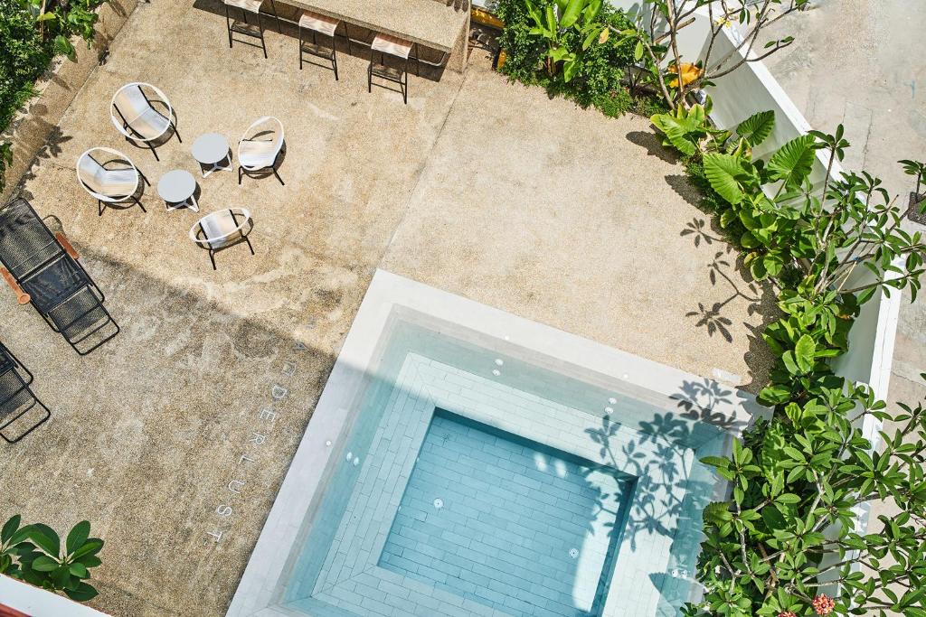 an overhead view of a swimming pool with chairs and tables at Wanderlust, The Unlimited Collection by Oakwood in Singapore