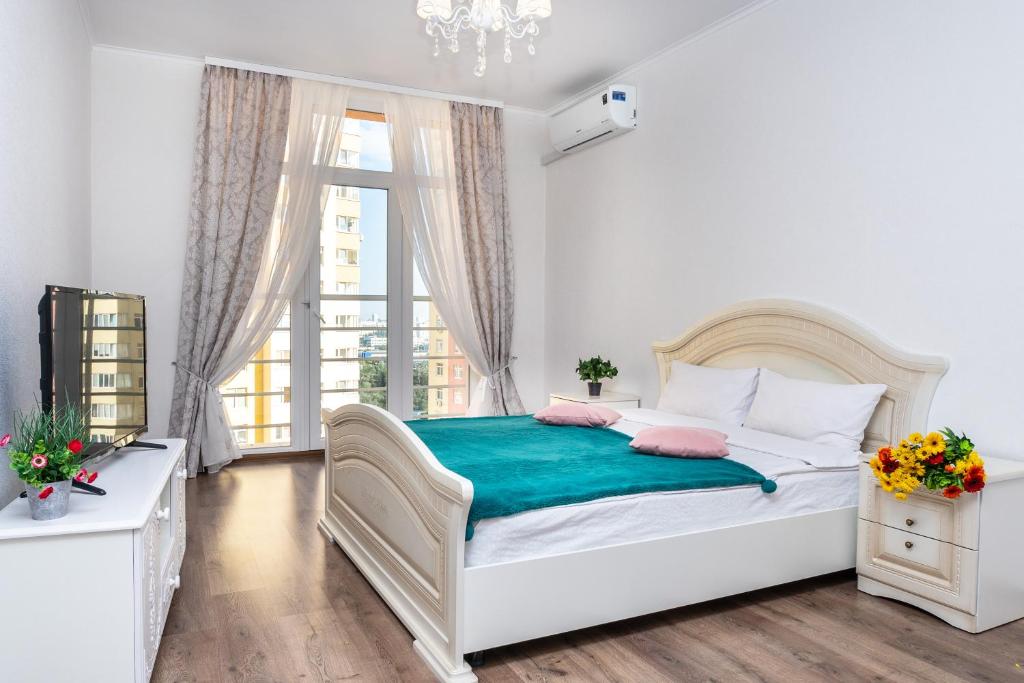 een witte slaapkamer met een bed en een raam bij Шикарная квартира на Оболони в ЖК Яскравый in Kiev