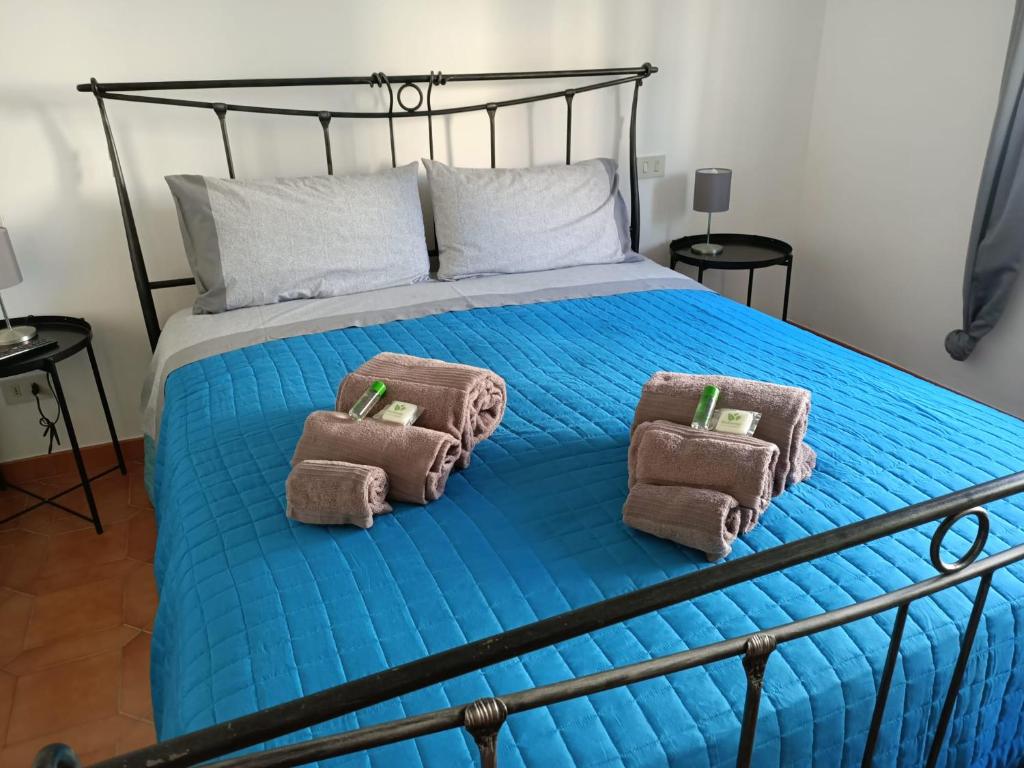 Una cama azul con dos toallas marrones. en Raffaello, en Iesi