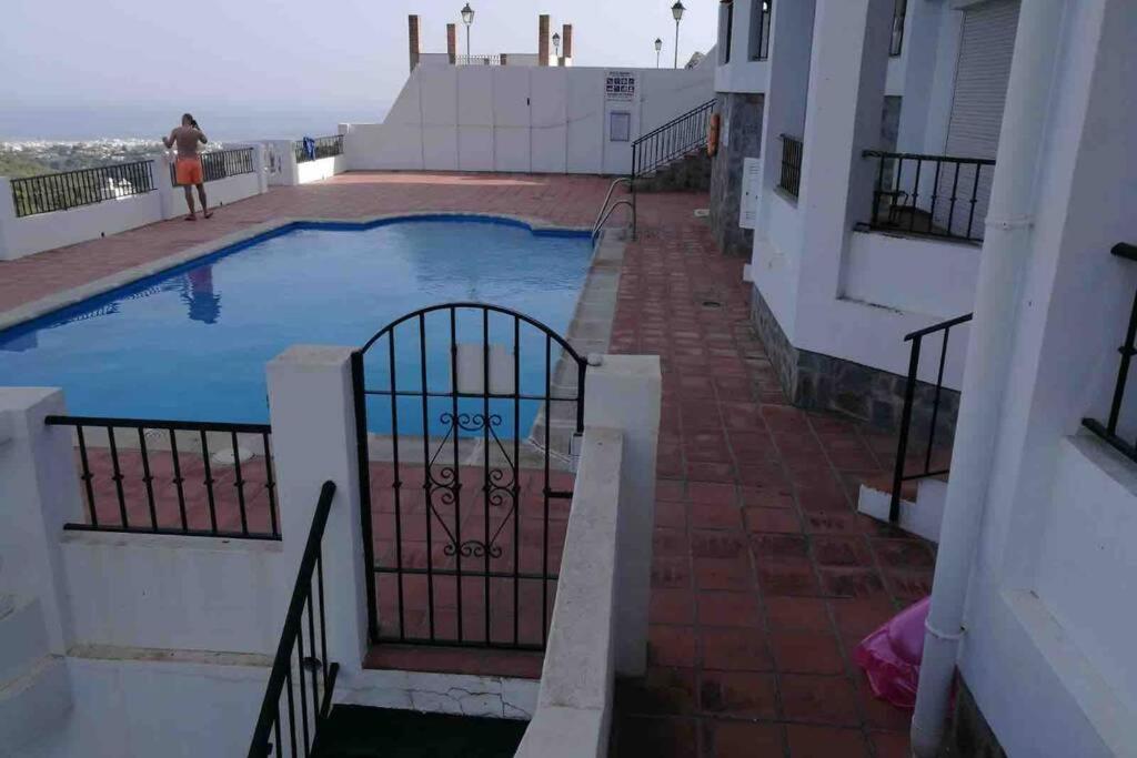 una piscina al lado de un edificio en Precioso apartamento de dos plantas con vistas, en Frigiliana