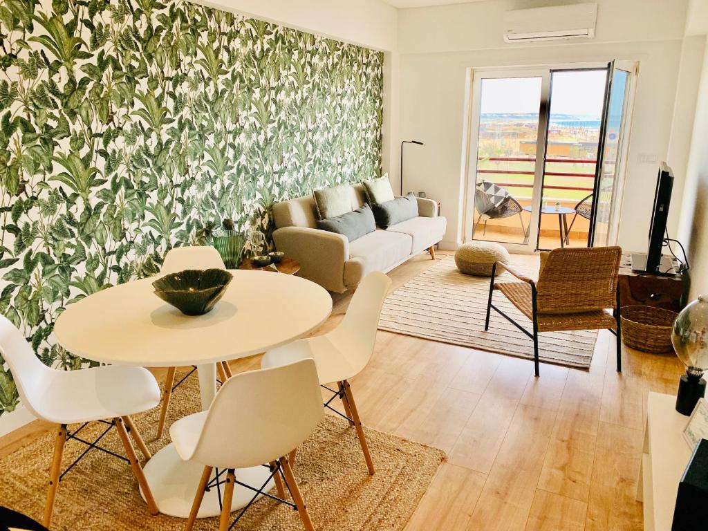 a living room with a table and chairs and a couch at Costa Caparica surf apartment in Costa da Caparica