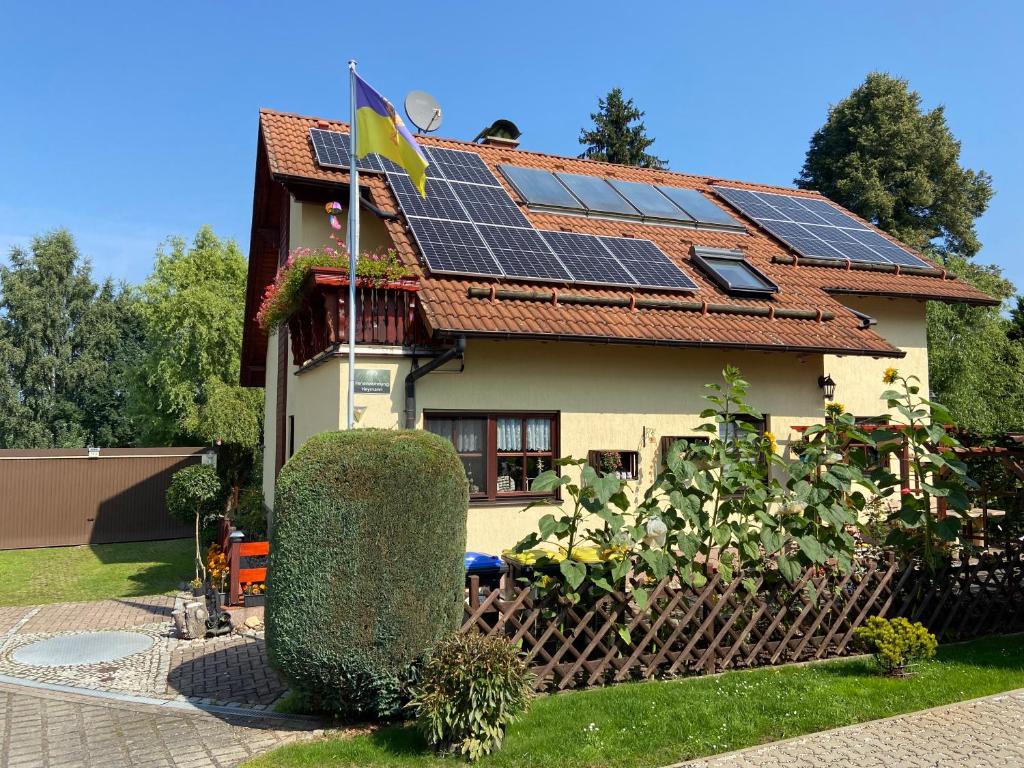 une maison avec des panneaux solaires sur le toit dans l'établissement Ferienwohnung Heymann, à Hörnitz