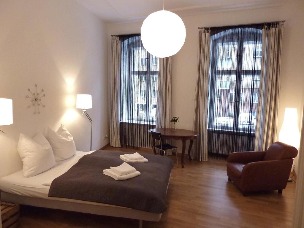 um quarto com uma cama, uma cadeira e janelas em apartment25 em Berlim