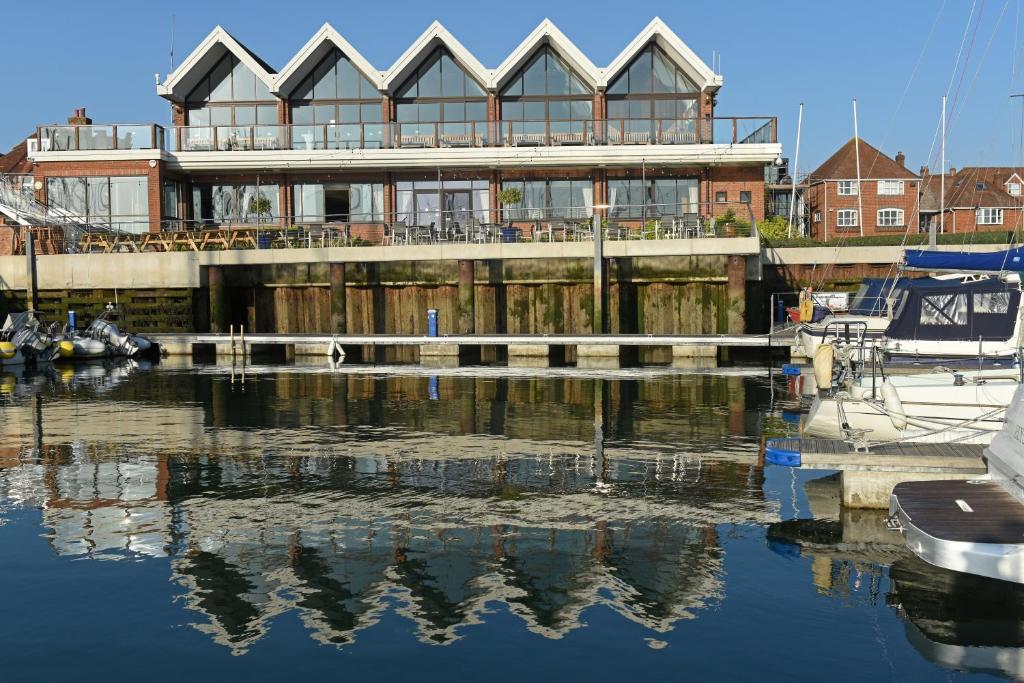 a building sitting on top of a body of water at Royal Southern Yacht Club in Hamble