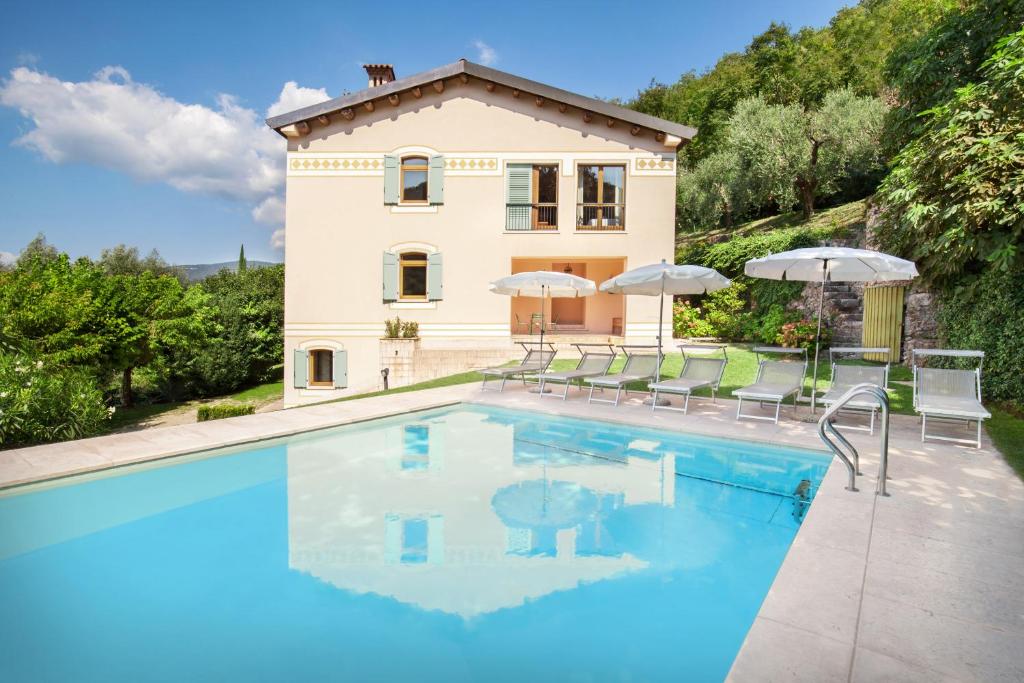 una villa con piscina di fronte a una casa di Cà Cantoni With Pool a Garda