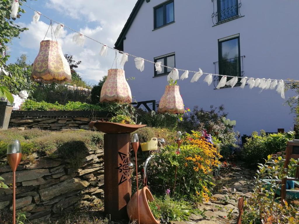 a garden with flowers and a house with a garland at Im Erzgebirge Wandern, Fahrrad fahren oder entspannen in Ehrenfriedersdorf