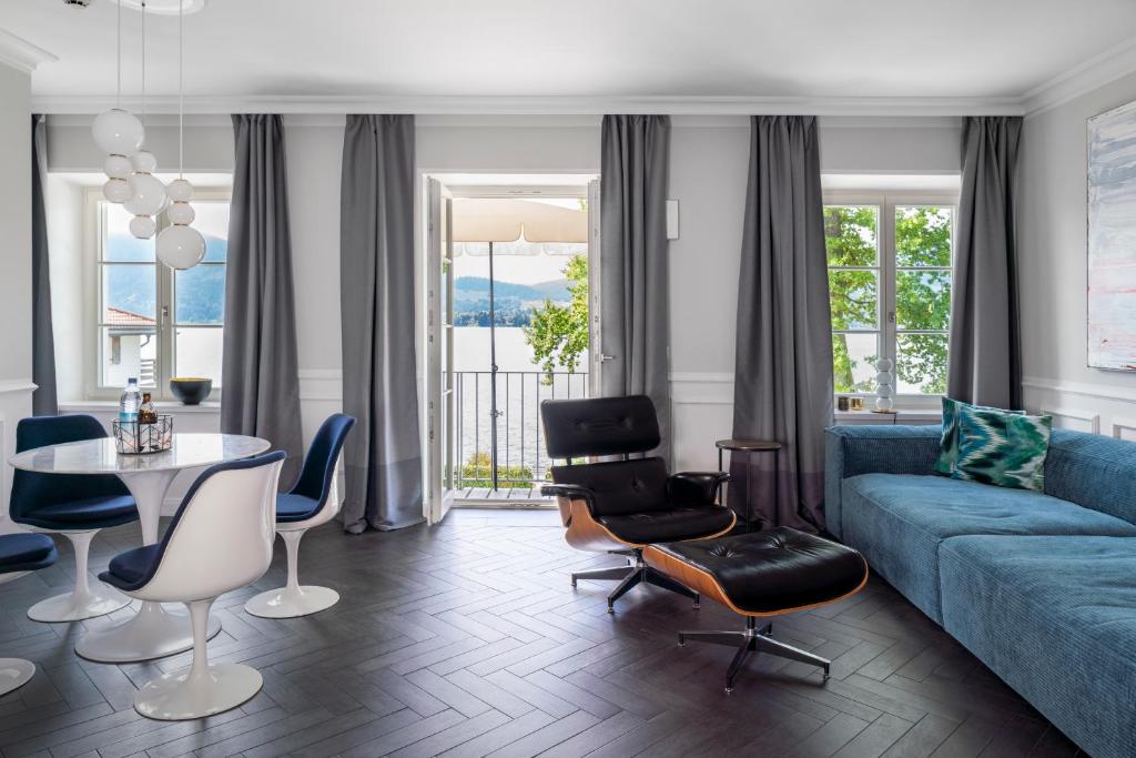 a living room with a couch and a table and chairs at Villa Palazzo in Tegernsee