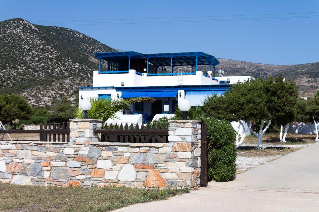 een blauw-wit gebouw met een stenen muur bij Vrahia Studios in Agiassos