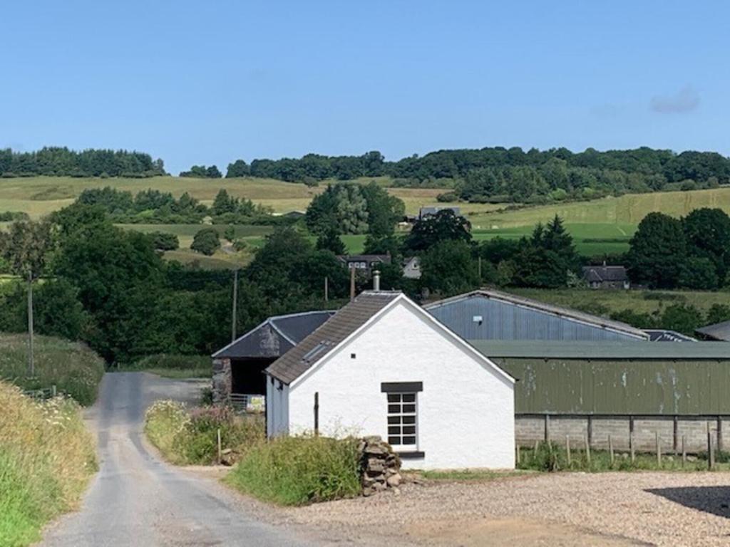 a white barn on the side of a road at Traditional bothy accommodation in Blairgowrie