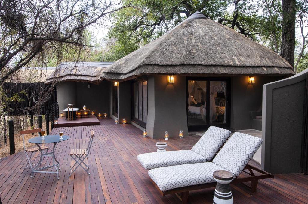 une grande terrasse avec des chaises et un toit de chaume dans l'établissement Jock Safari Lodge, à Skukuza