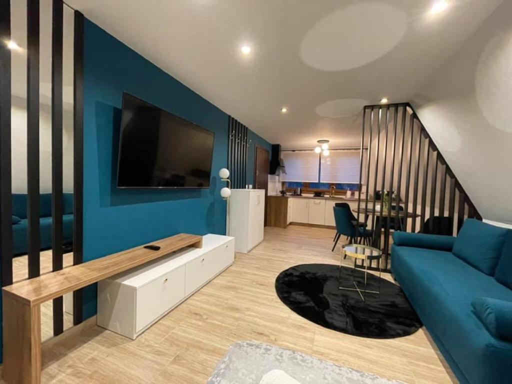 sala de estar con pared azul y sofá azul en Apartamenty Mrozówka en Poronin